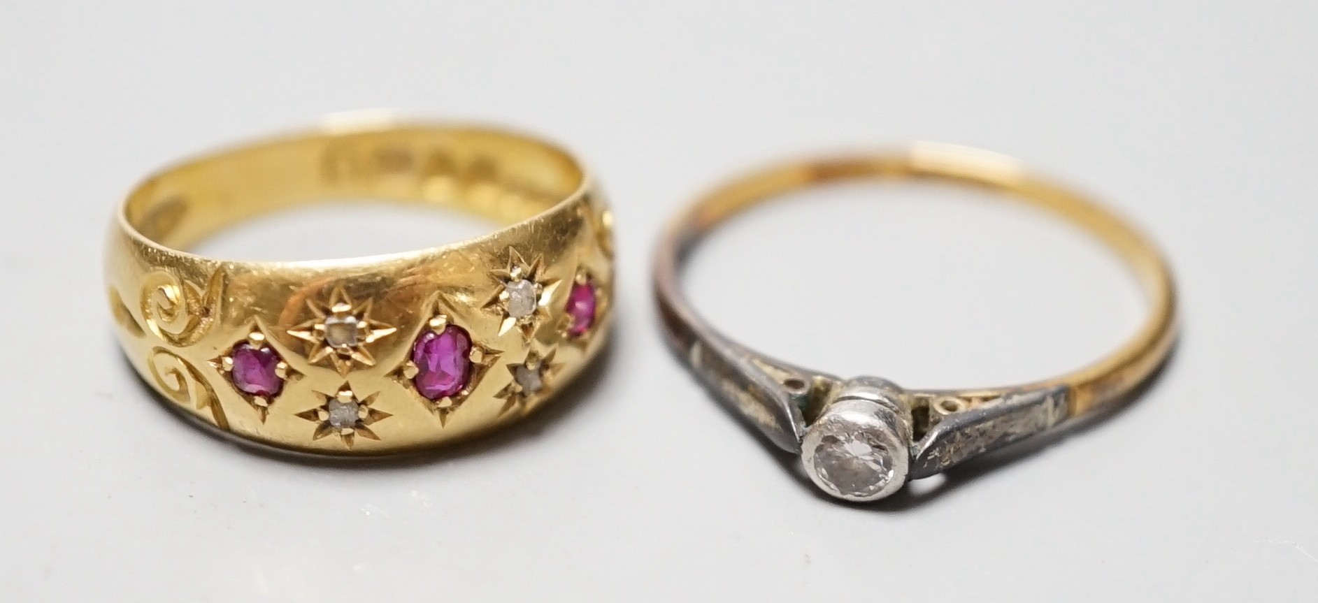 An Edwardian 18ct gold and gypsy set ruby and diamond chip set ring, size J/K and an 18ct and plat. collet set solitaire diamond ring, gross weight 4.8 grams.